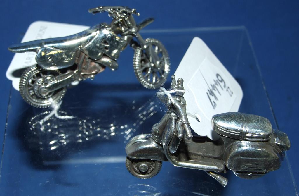 A small silver scooter, and a silver tri