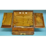 A burr walnut stationery box, the fitted interior above a single drawer opening to reveal a