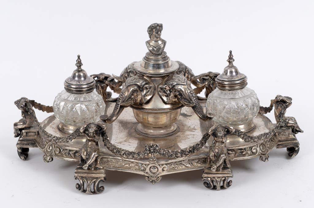 A Victorian silver plated ink stand, the central well with four elephant masks, flanked by a pair of