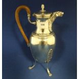 A silver coloured metal hot water jug, with an eagle mask spout,