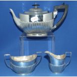 A George III style silver three piece tea service, with a reeded lower body, London 1895, approx.