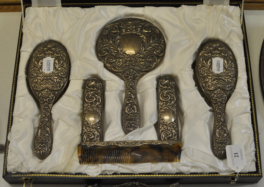 A silver six piece dressing table set, decorated stylised heads,