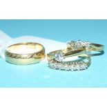 An 18ct gold and solitaire diamond ring, an 18ct gold and three stone diamond ring,