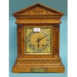 A mantel clock, the 15 cm wide brass dial with Roman numerals, in an architectural style oak case,