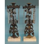 A pair of cast metal candlesticks, decorated lilies, with prismatic drops, on marble bases, 37.