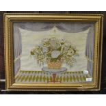 A Victorian woolwork picture, decorated a vase of flowers, within a drape surround,
