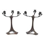 A pair of Art Nouveau WMF style three branch bronze candelabra, with stylised decoration, 31 cm high