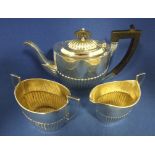 A George III style silver three piece bachelor tea set, with a reeded lower body, Sheffield 1895,
