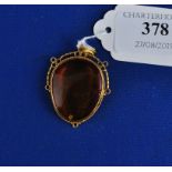 An Arts & Crafts yellow coloured metal and amber pendant, the amber containing a fly Condition