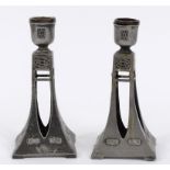 A pair of WMF pewter candlesticks, on square pierced spreading columns, with stylised decoration and