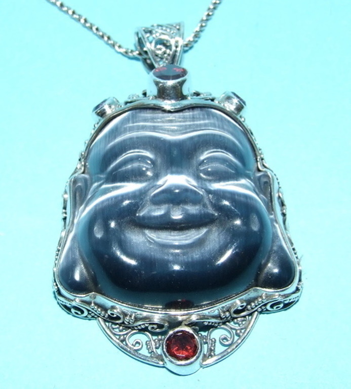 A Buddha head pendant, in silver, set wi