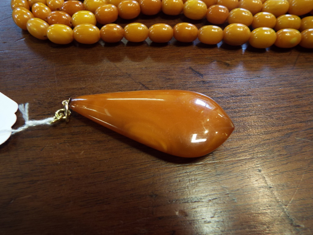 A string of amber style beads, with a te - Image 8 of 10