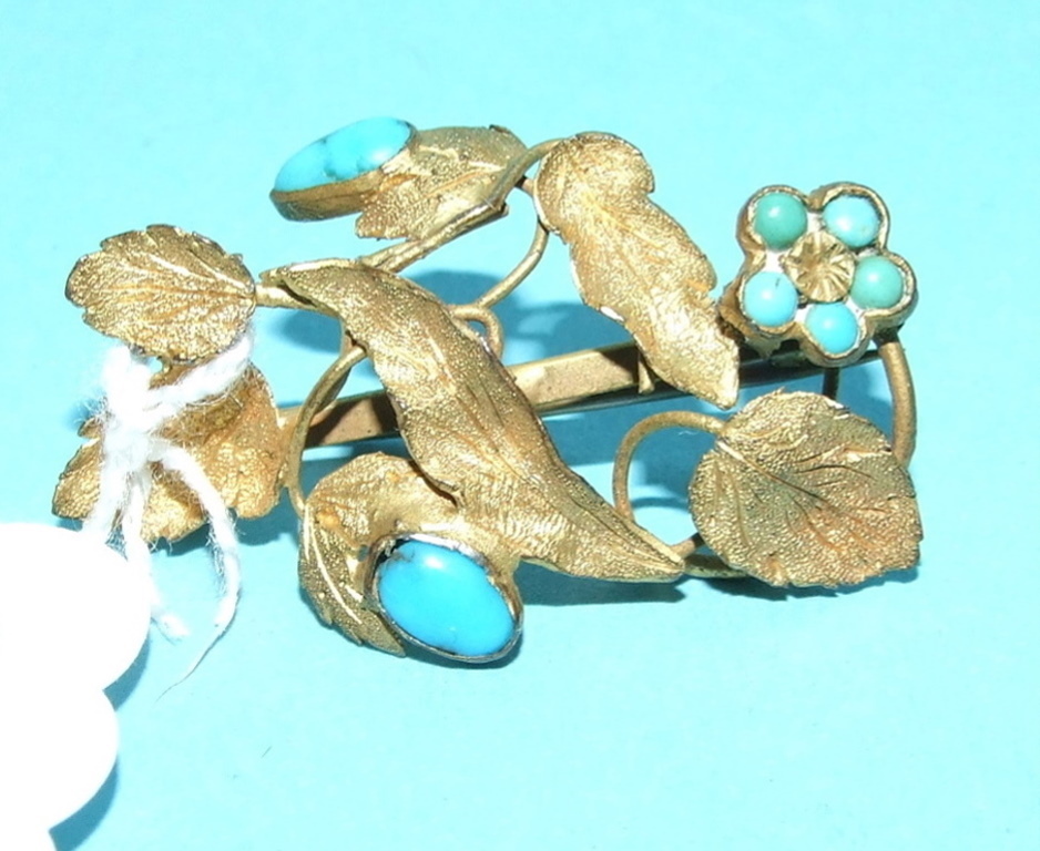 A yellow coloured metal and turquoise br