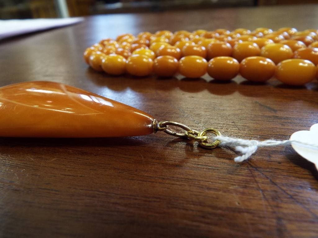 A string of amber style beads, with a te - Image 9 of 10