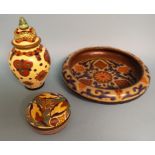 A Gouda pottery vase and cover, decorated stylised flowers, 24 cm high, a similar box and cover, 11.