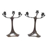 A pair of Art Nouveau WMF style three branch bronze candelabra, with stylised decoration,
