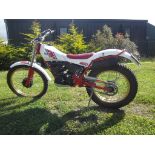 A 1989 Yamaha TY250 trials, registration number F181 OFC, white and red.