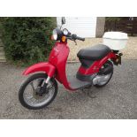 A 1999 Honda Sky SGX50 scooter, registration number T874 PDG, red.