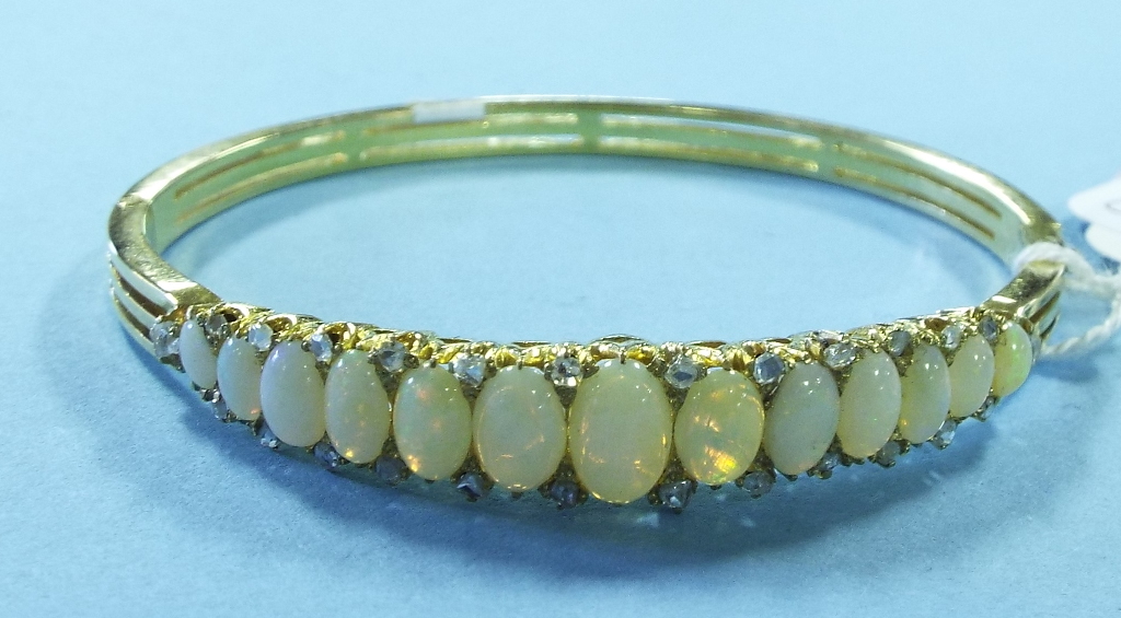 A yellow coloured metal, opal and diamon