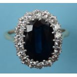 A sapphire and diamond cluster ring, the large oval cut sapphire within a diamond surround,