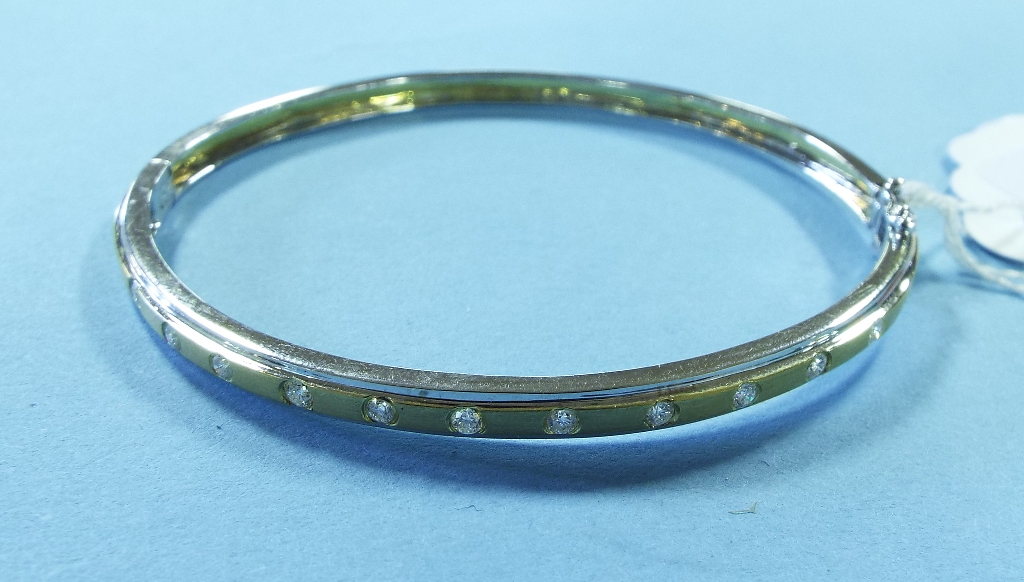 An 18ct yellow and white gold bangle, se