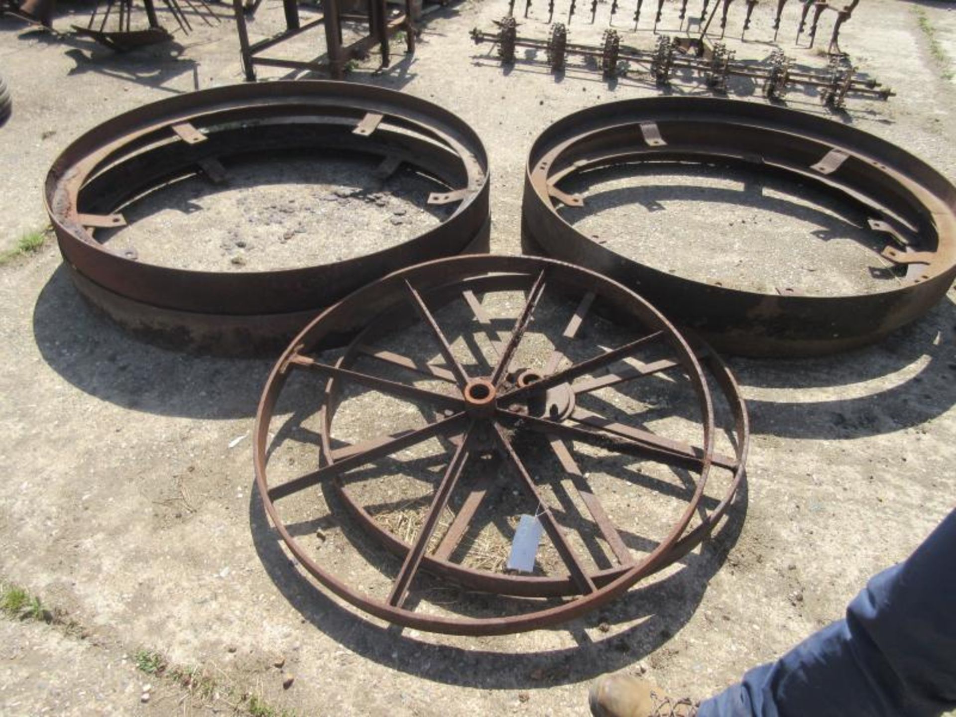 4no. large iron wheel bands t/w 2no. spoked iron wheels