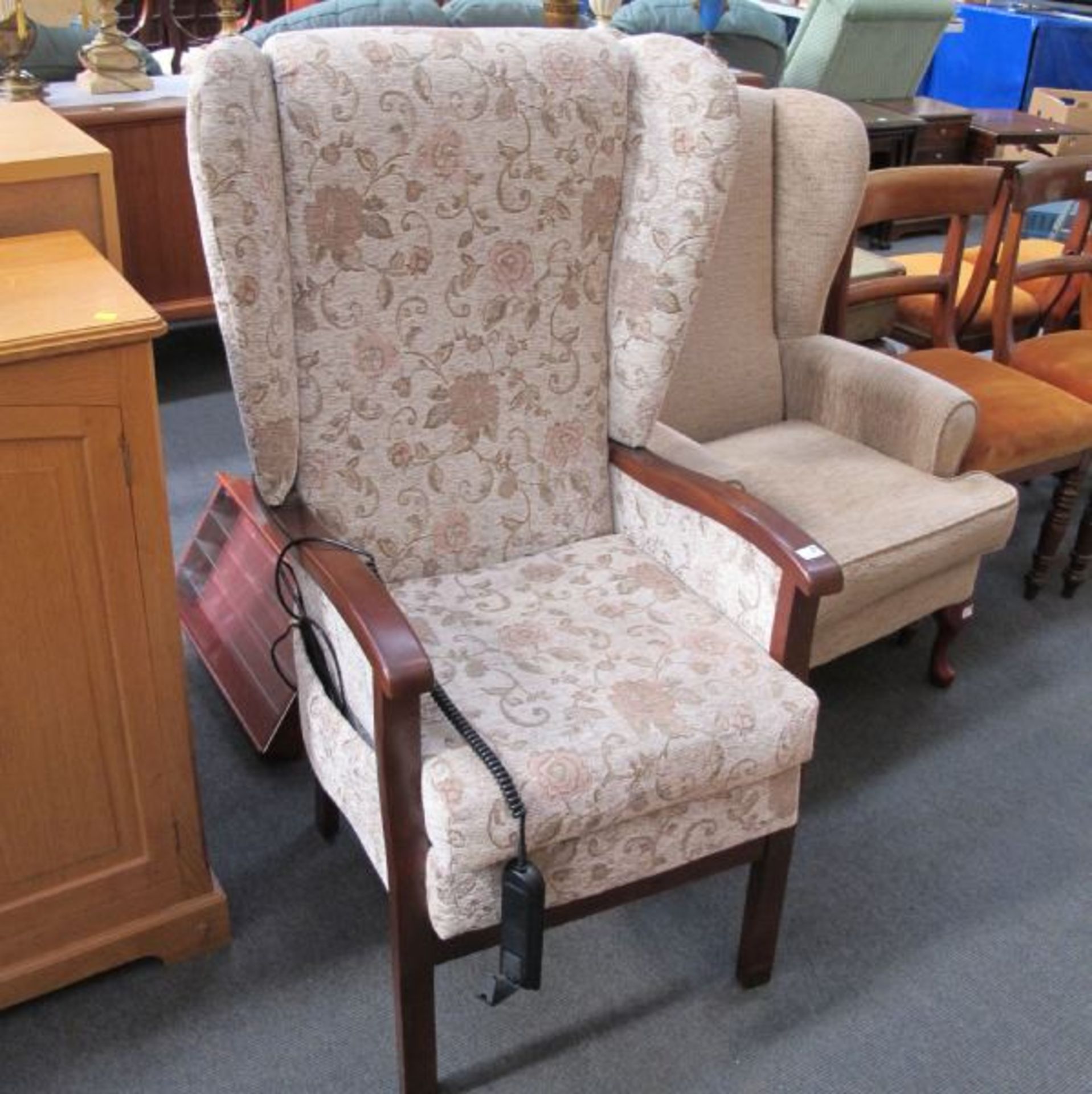 An Electrically Operated Lift-Seat Wing Back Fireside Chair.  (est. £40-£60)