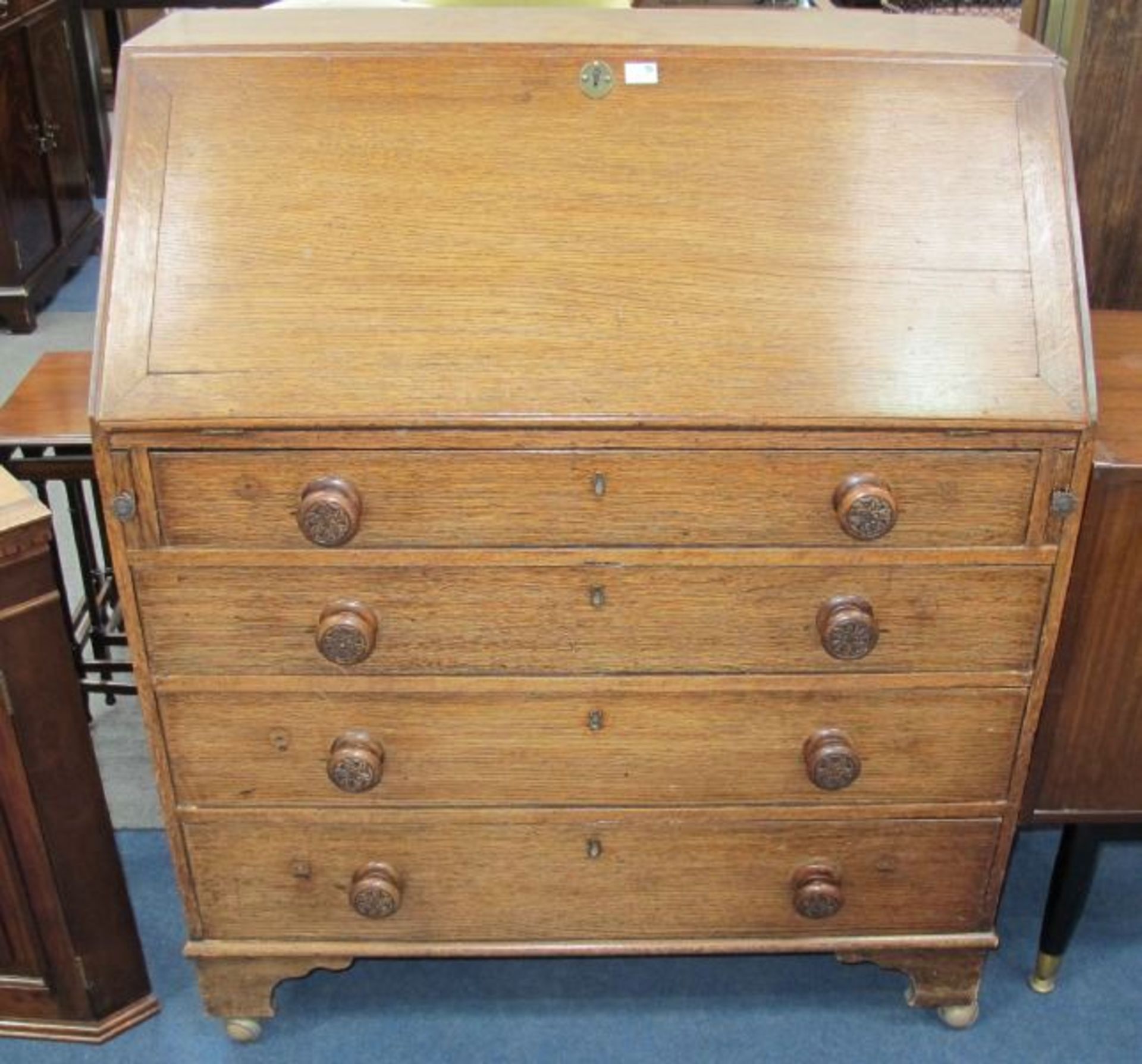 A Georgian Oak Bureau with Plain Writing Flap enclosing an Interior of Pigeon Holes and Trays,