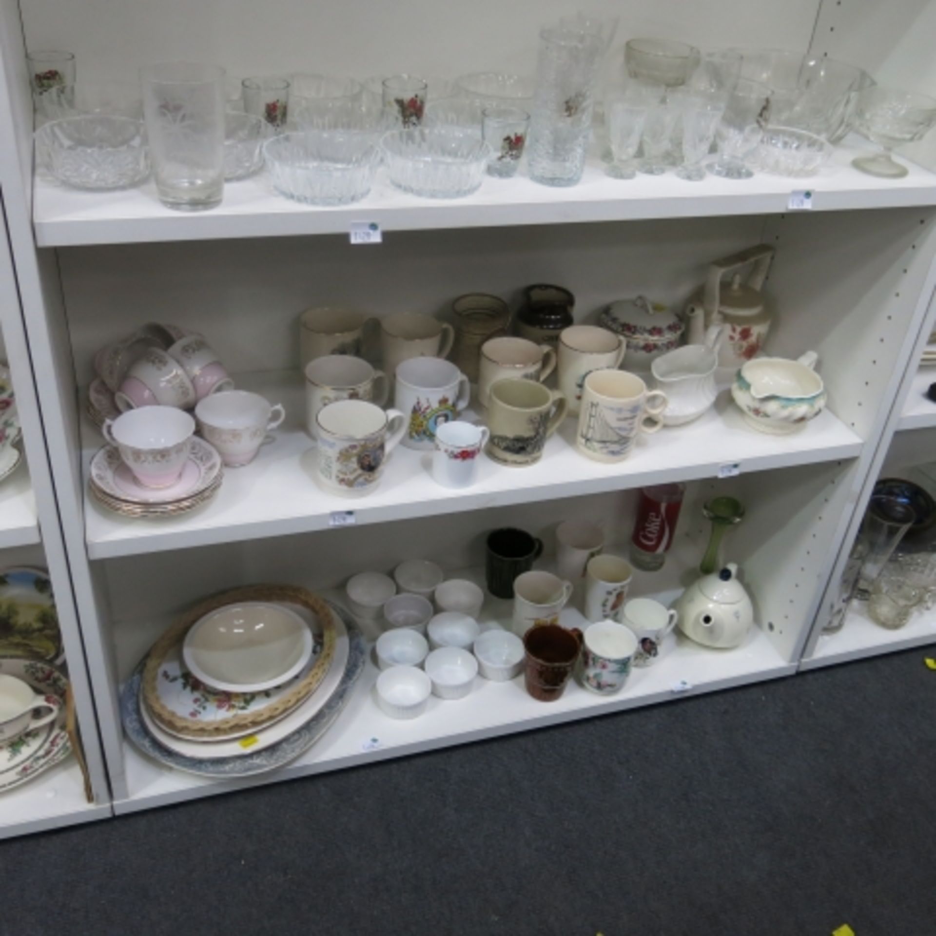 Three shelves containing various cut glassware, teapots, gravy boat, commemorative cups, small tea