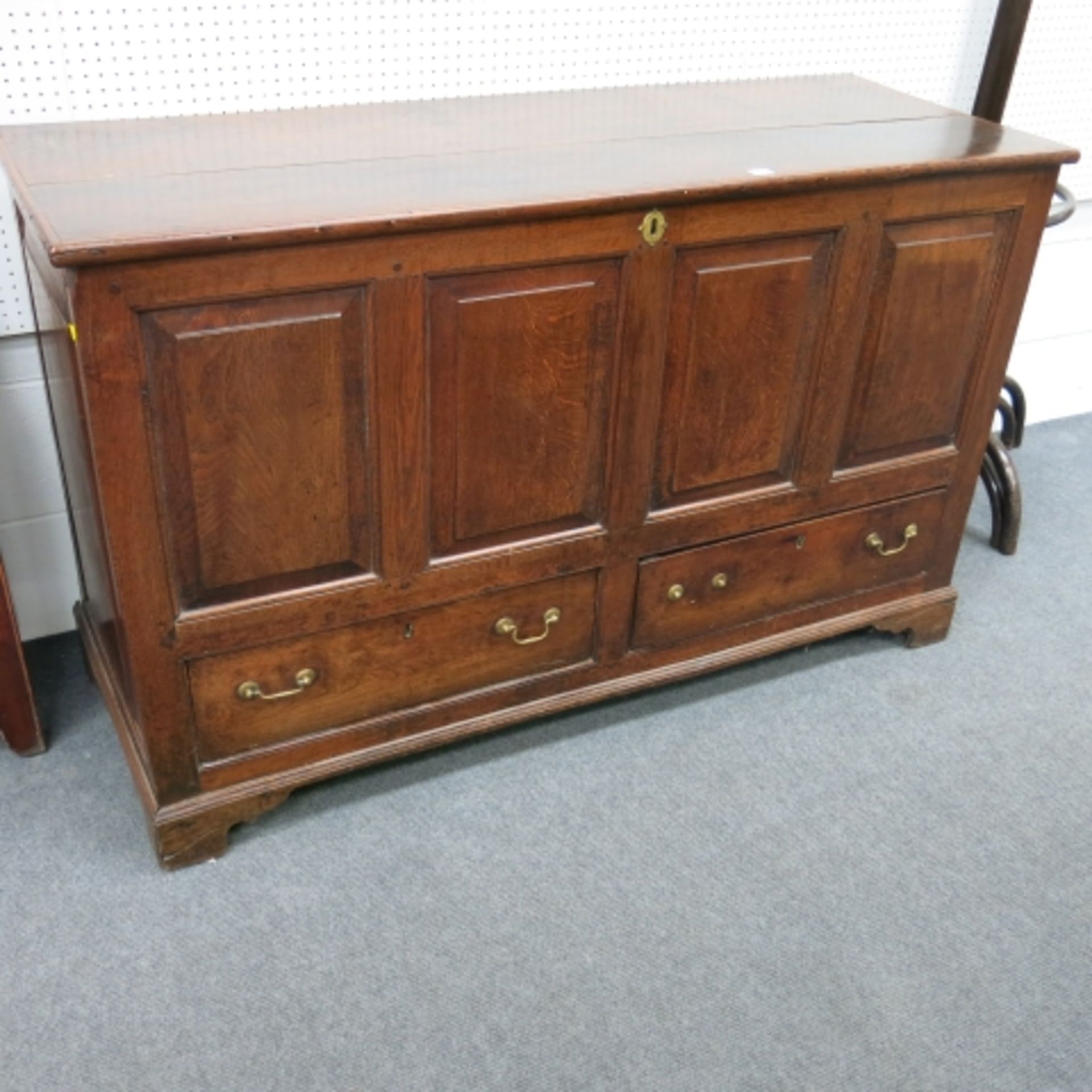 An 18th Century oak mule chest with plain top, panelled front, two drawers and bracket supports