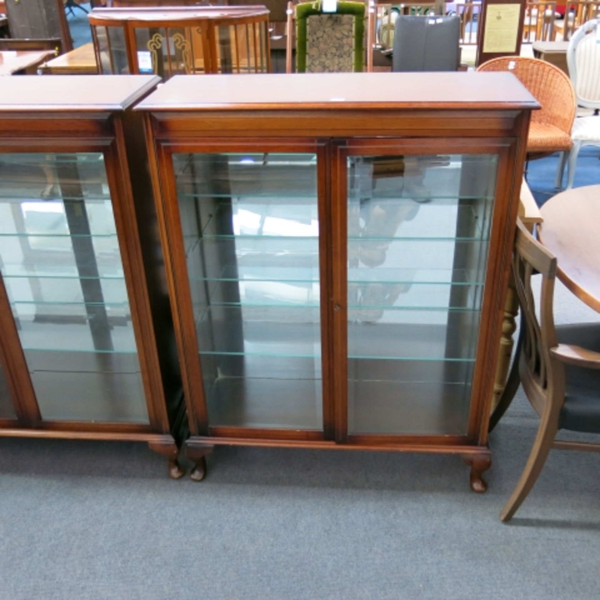 A pair of mahogany finish display cabinets each with two bevelled glass doors enclosing adjustable