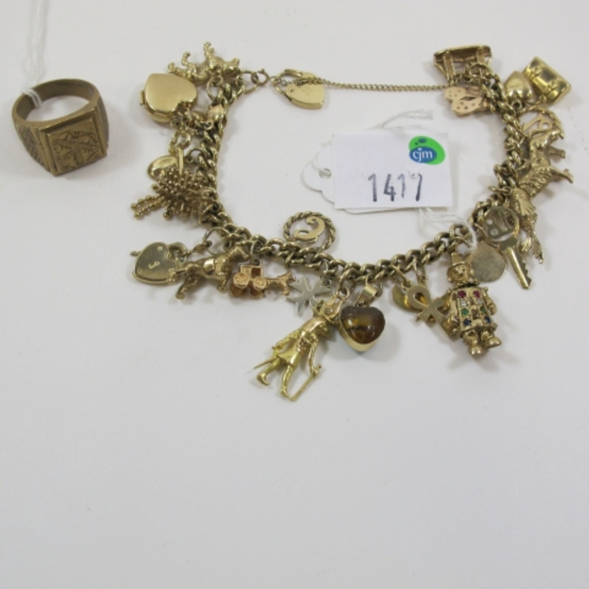 A Charm Bracelet With Over 20 Mixed Charms. One Of The Charms Is Stamped .375; Together With a Gents