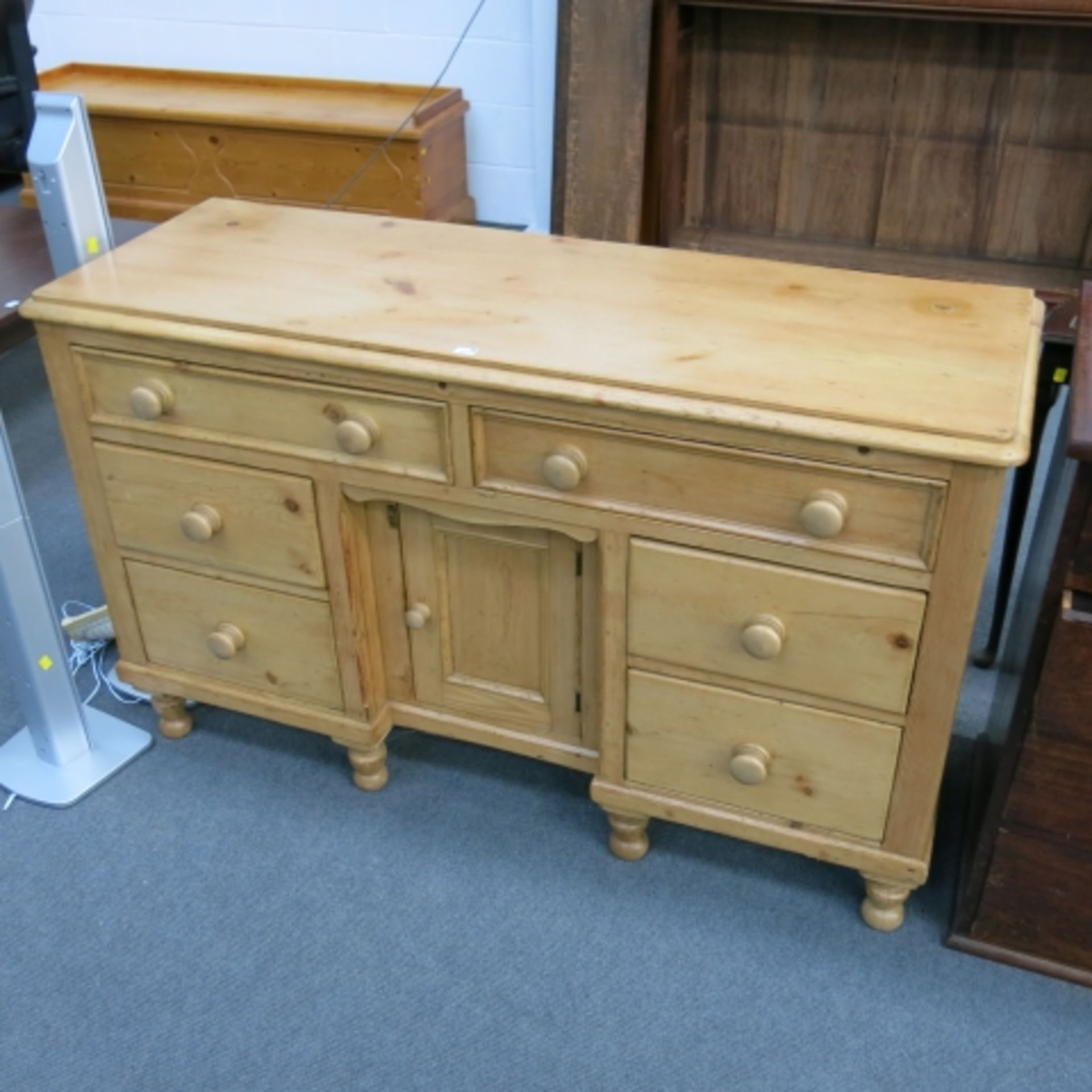 A Victorian stripped and polished Lincolnshire pine dresser (base) with central cupboard flanked