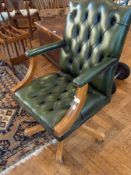 A green swivel button-back office armcha