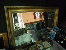 A mirror with a gold painted frame