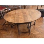 An old global topped oak gateleg table,