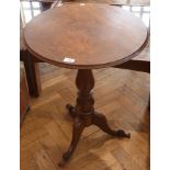 A walnut circular top tripod table with