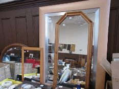 A rectangular wall mirror within a plain