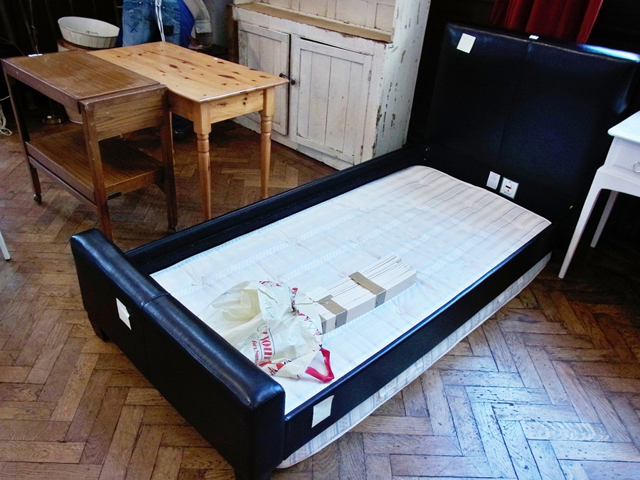 A modern single bed with faux leather he
