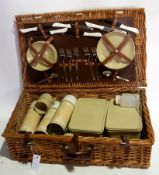 A wicker picnic hamper including six pla