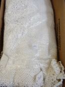 A cream coloured crocheted bed cover and