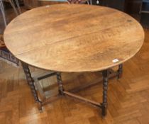 An old oval topped oak gateleg table, wi