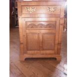 An oak side cupboard with frieze drawer,