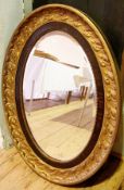 Gilt metal and faux-wood wall mirror, ov