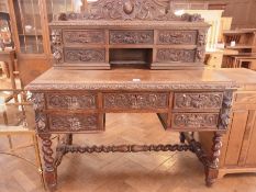 A Victorian carved oak desk, the raised