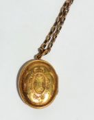 Gold coloured metal locket on gold colou