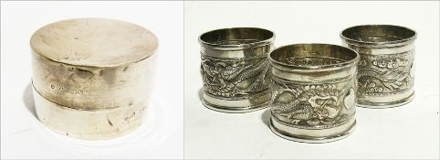 Three Chinese silver coloured metal napkin rings with dragon frieze decoration and a hallmarked