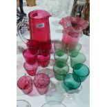 A selection of coloured glass items including a large cranberry glass water jug,