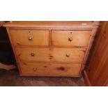 A pine chest of drawers with two short d