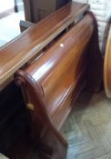 Stained wood sleigh bed with fitted bed